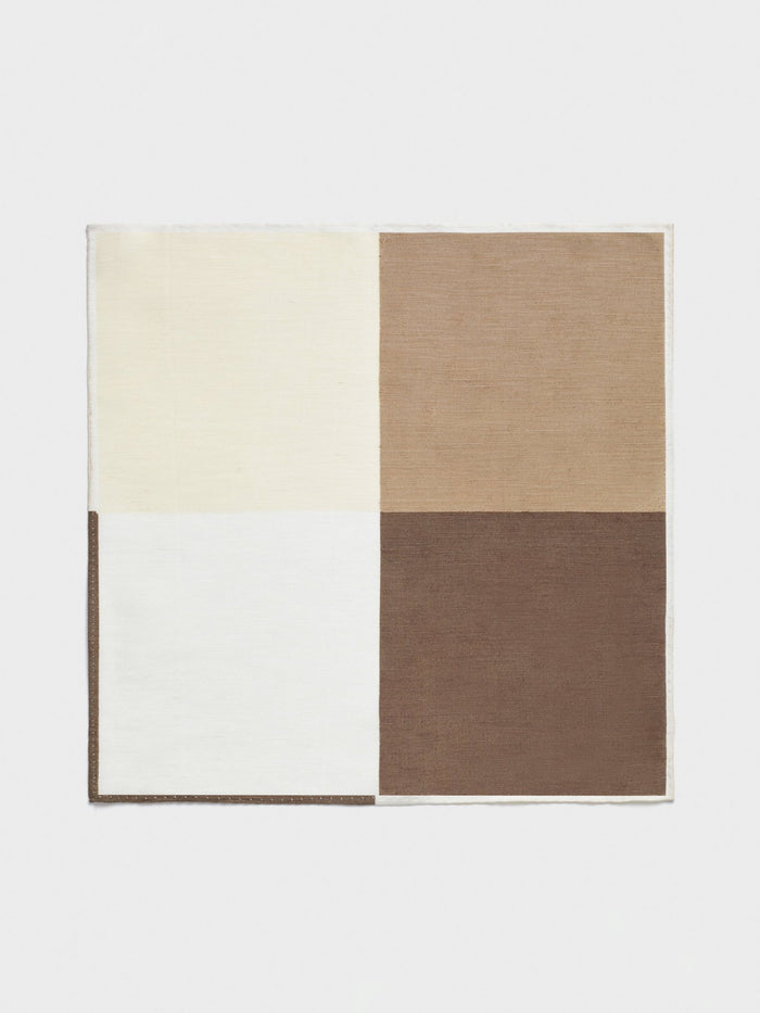 Brown quad pocket square laid flat, four color blocks: cream, tan, white, and dark brown.