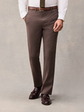 Cropped front view of a man in brown suit trousers with an olive tie and brown belt.