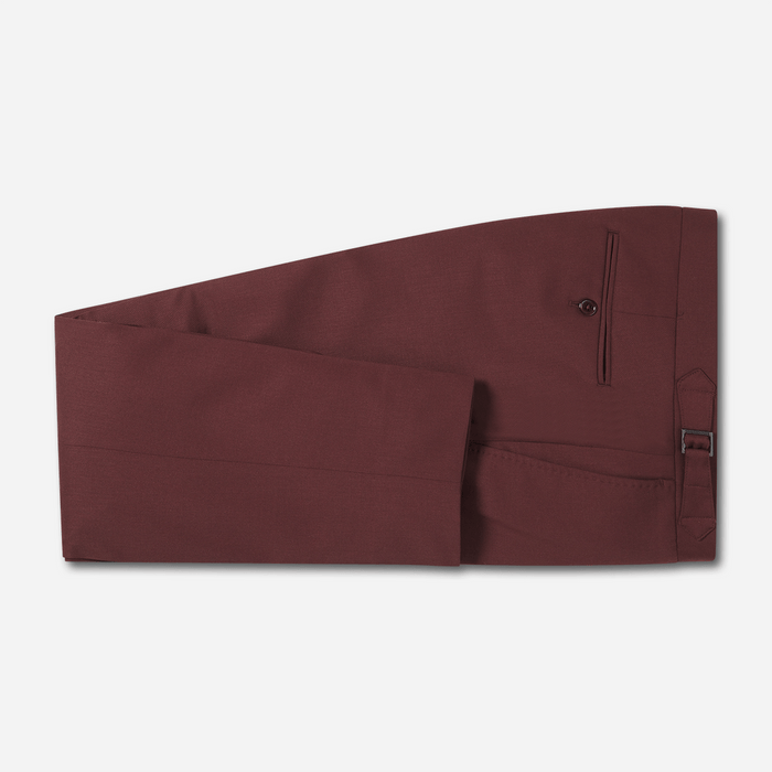 Burgundy tuxedo trousers folded flat, side buckle strap and pocket visible.