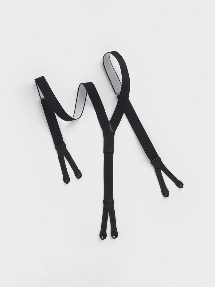 Black button suspenders laid flat on a white background.