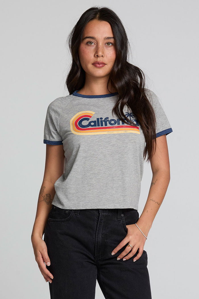 Back view of a woman wearing the Chaser California Dreamin Tee and black jeans on a neutral background