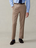 Cropped front view of a man in camel suit trousers, light blue shirt, and navy tie.