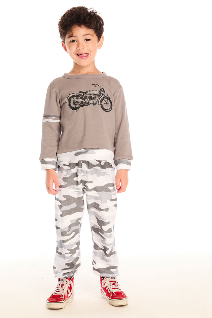 Full body view of boy wearing Chaser’s Camo Pants in gray camouflage with matching Moto Rider top on a white background.