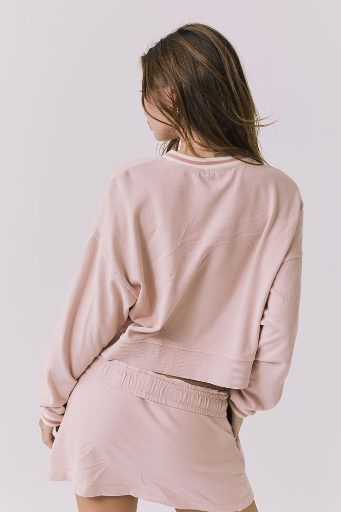 Back view of the Chaser Campbell Honey Peach Pullover highlighting the relaxed fit and soft vintage-wash fabric, paired with the Soleil Mini Skort