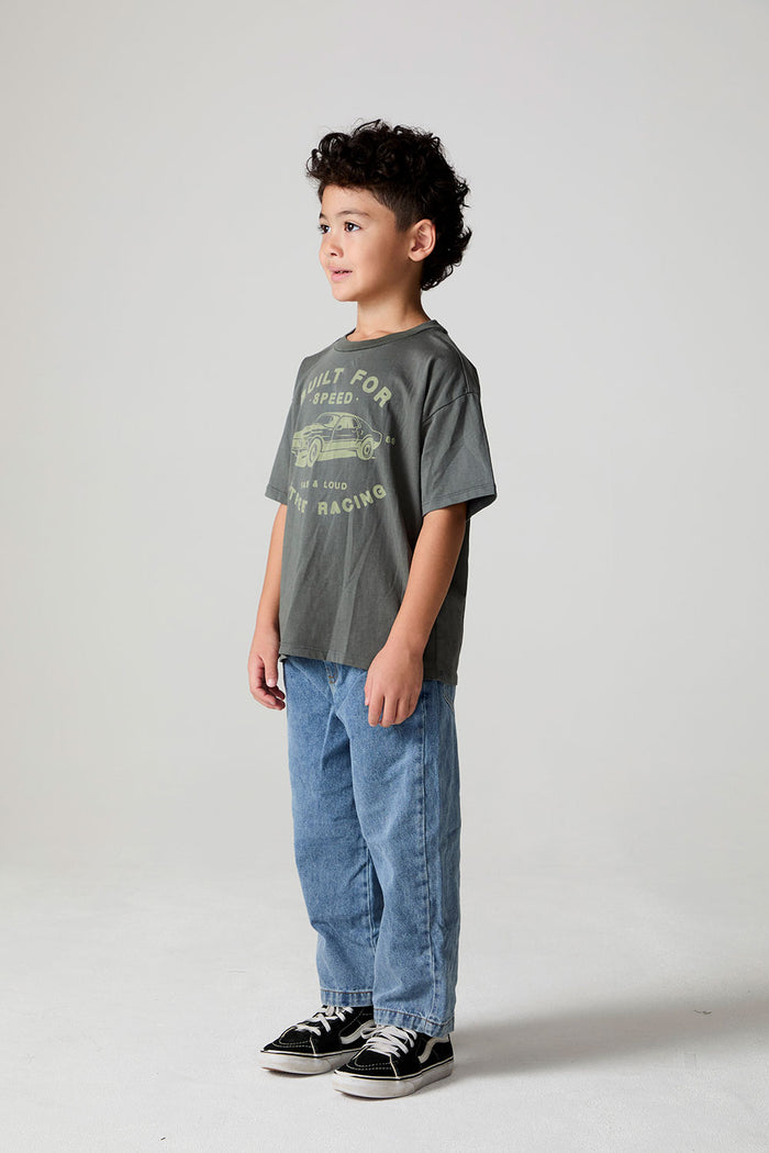 Full body side view of a boy wearing the Chaser  Car Show Tee on a neutral background