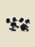 Set of black rose-carved cufflinks and shirt studs on a beige background.