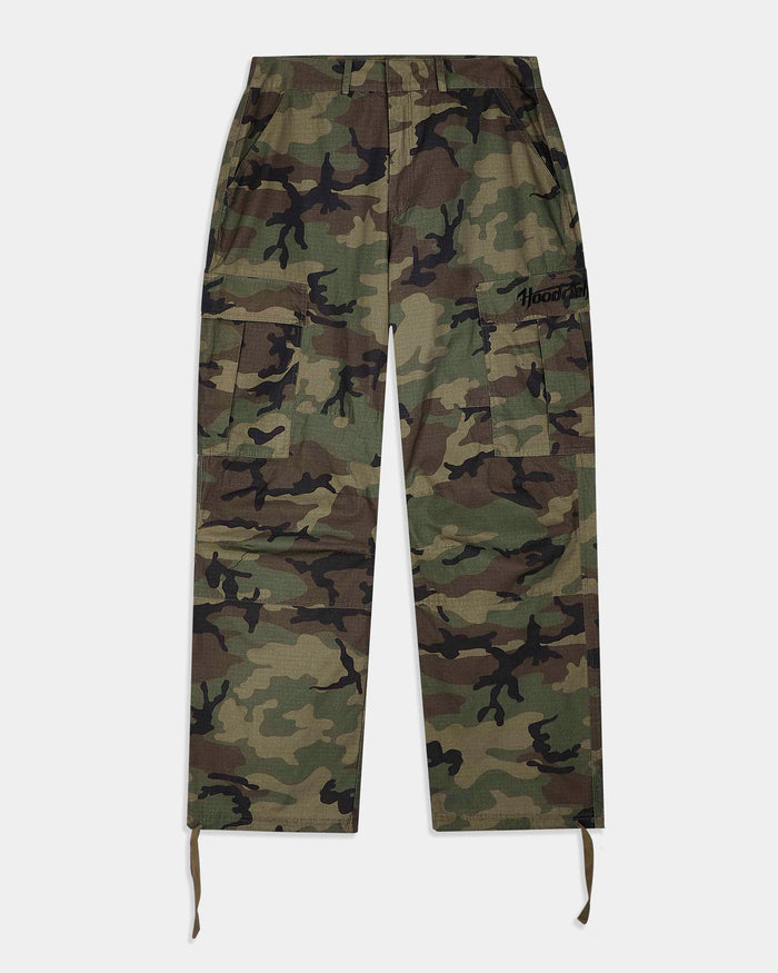 A pair of camouflage cargo pants with a green, brown, and black camo pattern, featuring a drawstring waist and hem, and a small black embroidered logo on the right thigh.