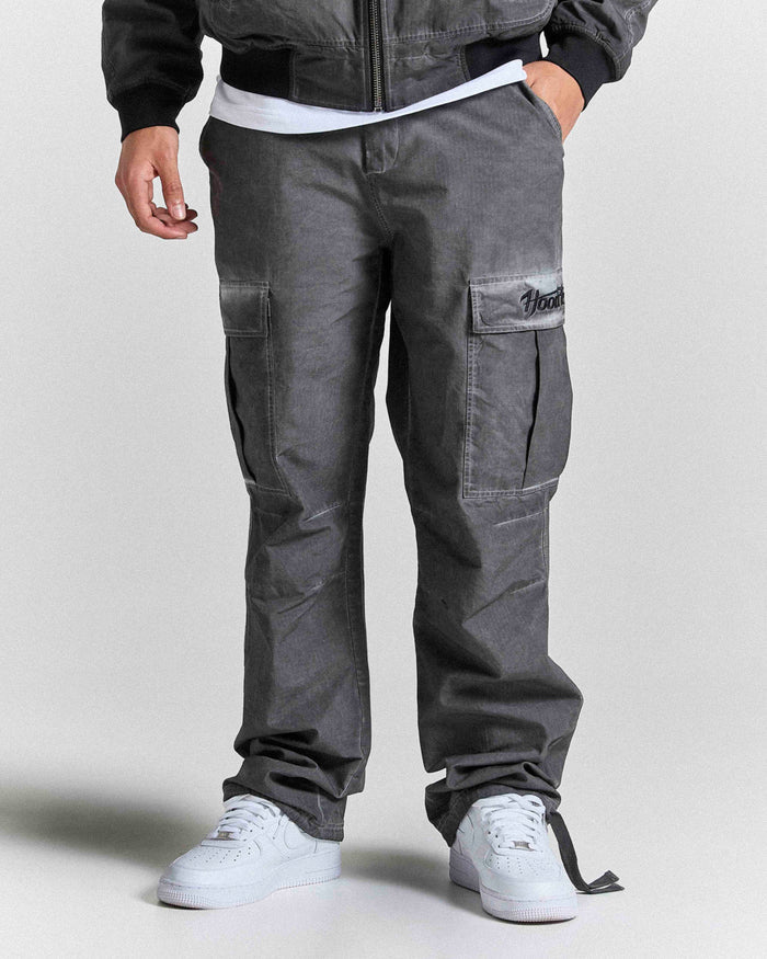 Person wearing gray cargo pants with a plain background