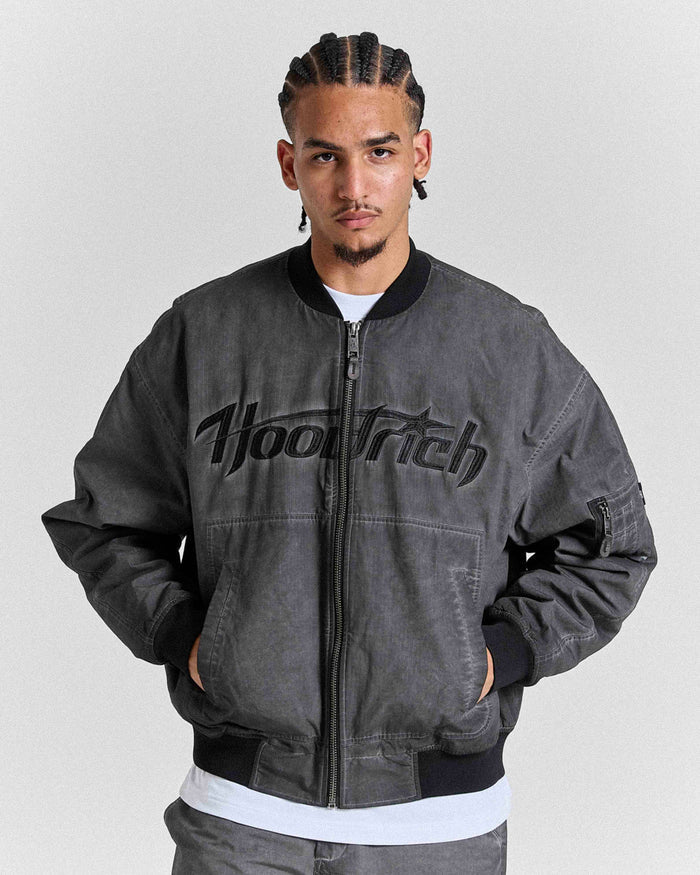 Man wearing a gray jacket with 'Hoodrich' branding on a light gray background