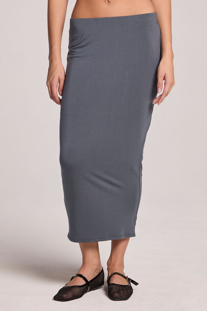 Front of a woman wearing the Chaser Future Grey Catch Midi Skirt  and mary janes on a neutral background