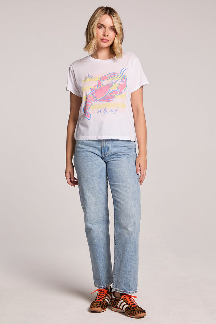 Front view of a woman wearing the Chaser  Catch Of The Day Tee and sneakers on a neutral background