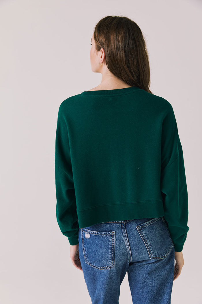 Back view of woman wearing Chaser’s Blue Grass Green C’est Le Weekend Long Sleeve on a plain background