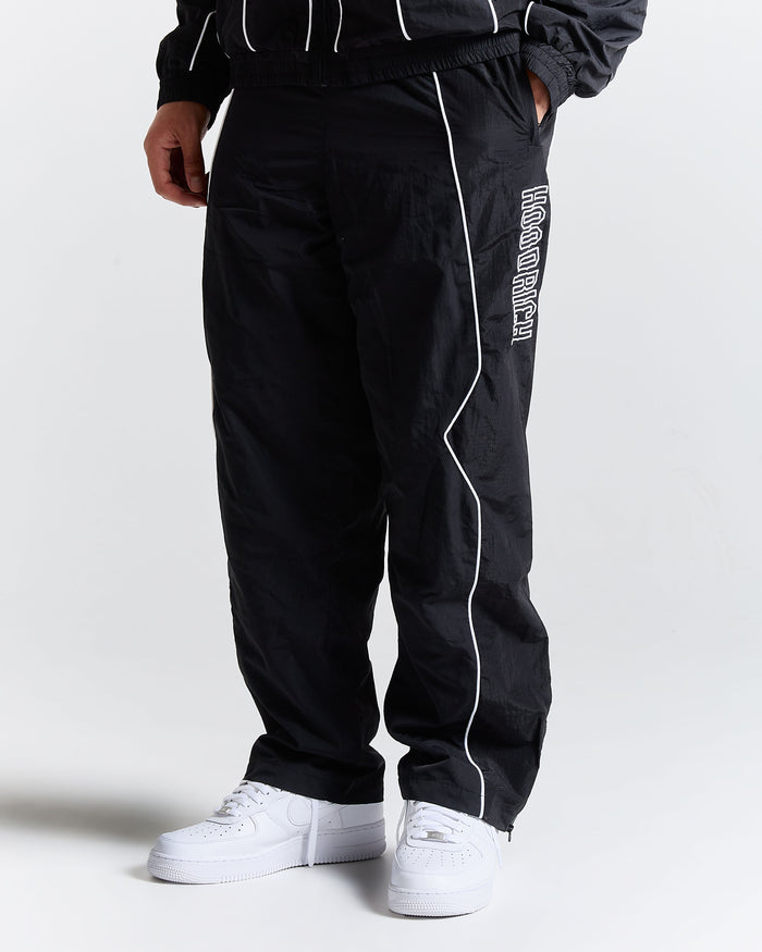 Black track pants with white piping and text on a white background