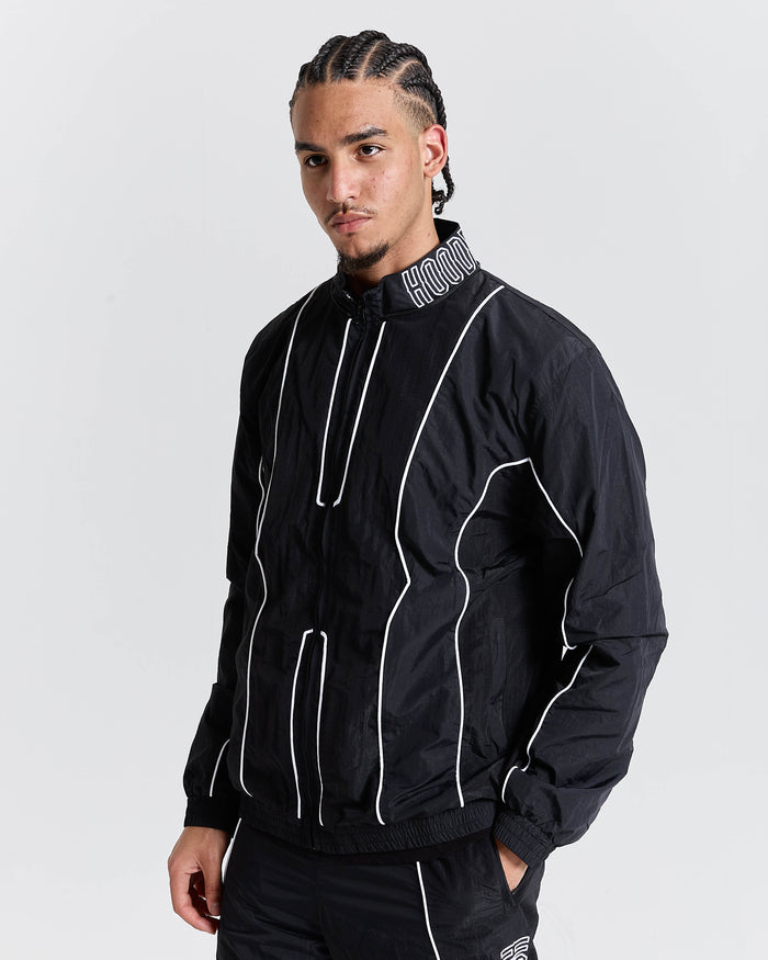 Person wearing a black jacket with white accents on a gray background