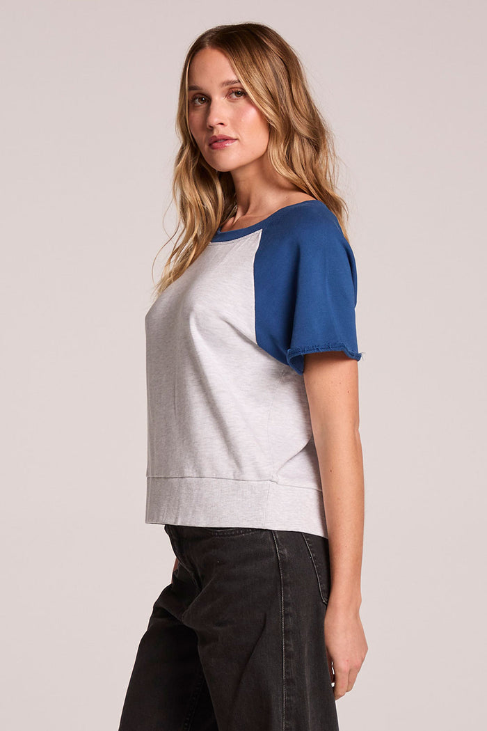 A side view of a woman wearing the Chaser Cheyenne Admiral and Light Grey Pullover  on a neutral background with arms at her sides