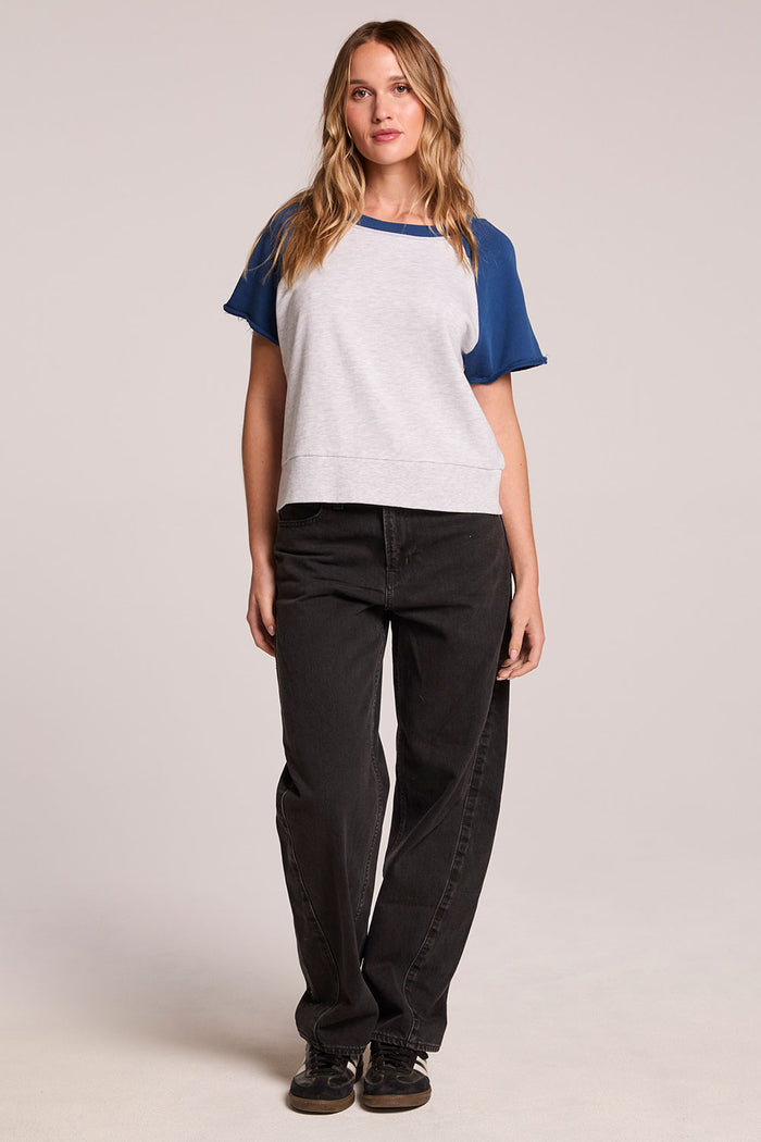 A full body front view of a woman wearing the Chaser Cheyenne Admiral and Light Grey Pullover and black sneakers on a neutral background