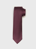 Chianti silk necktie with twill texture, rolled at the top, on a grey background.