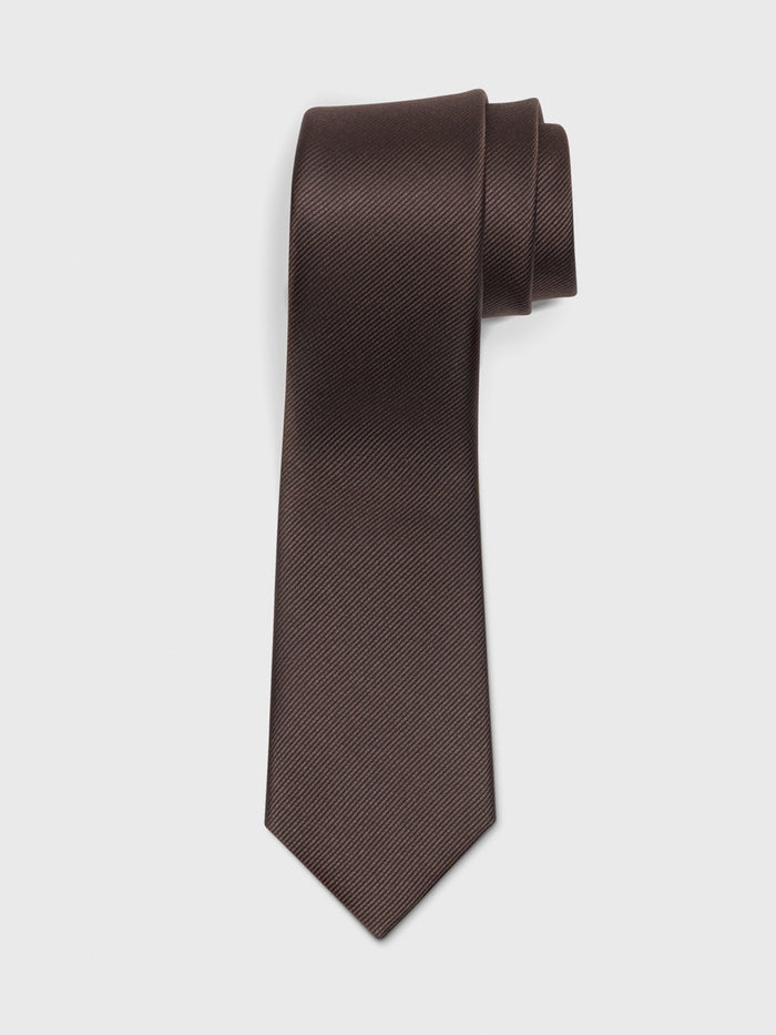 Chocolate silk necktie with twill texture, rolled at the top, on a grey background.