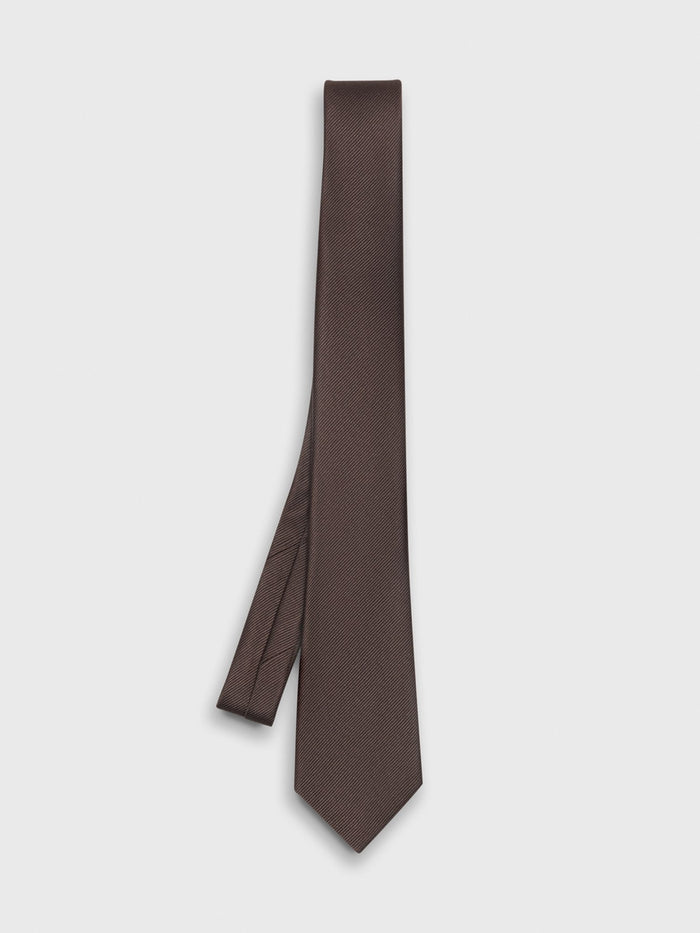 Chocolate brown silk necktie laid flat in a loose diagonal fold on a grey background.