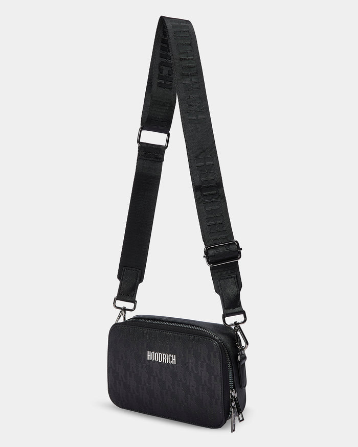 Black crossbody bag with a strap on a light gray background