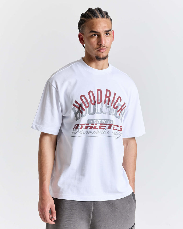 Man wearing a white t-shirt with red and black text on a plain background