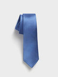 Cobalt silk necktie with twill texture, rolled at the top, on a grey background.