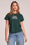 Front view of a woman wearing the Chaser   Coca Cola Tennis Club Tee  and jeans on a neutral background