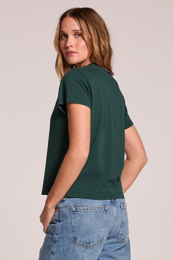 Back view of a woman wearing the Chaser   Coca Cola Tennis Club Tee on a neutral background