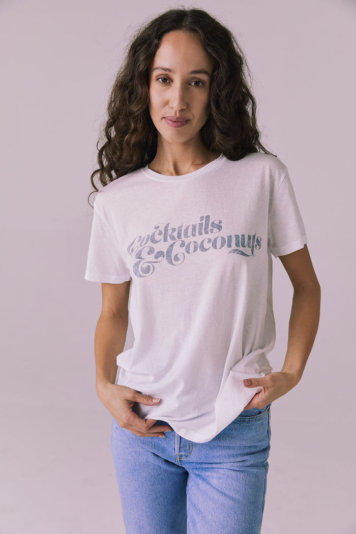 Model wearing the Chaser Cocktails & Coconuts Tee in White featuring a relaxed fit with vintage-inspired text across the chest