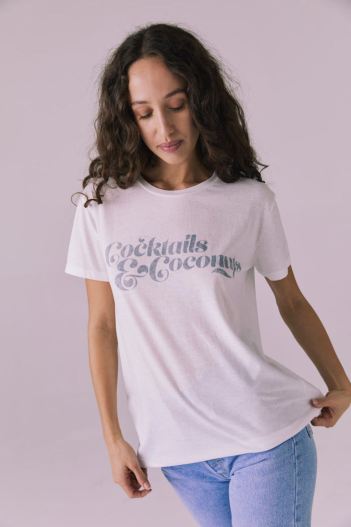 Model wearing the Chaser Cocktails & Coconuts Tee in White featuring a relaxed fit with vintage-inspired text across the chest