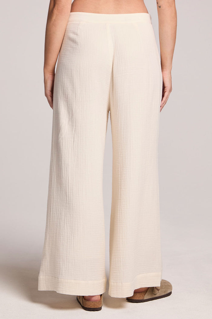 Back view of a woman wearing the Chaser Coconut Milk Campaniaa Trousers on a neutral background