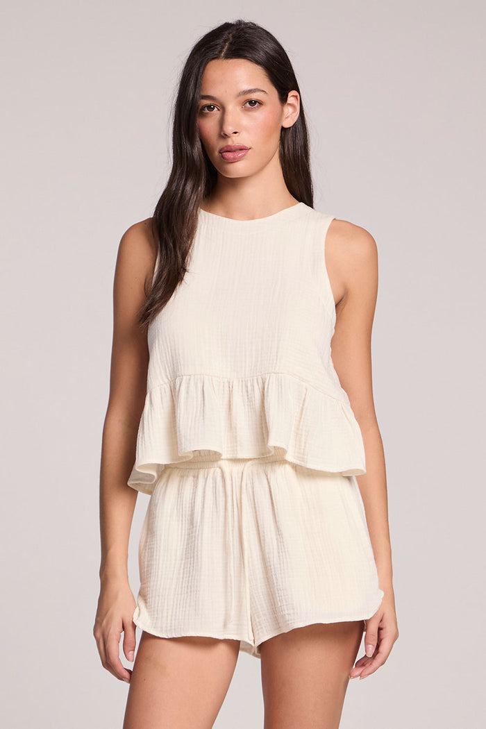 Front view of a woman in a matching tank and shorts set on a neutral background