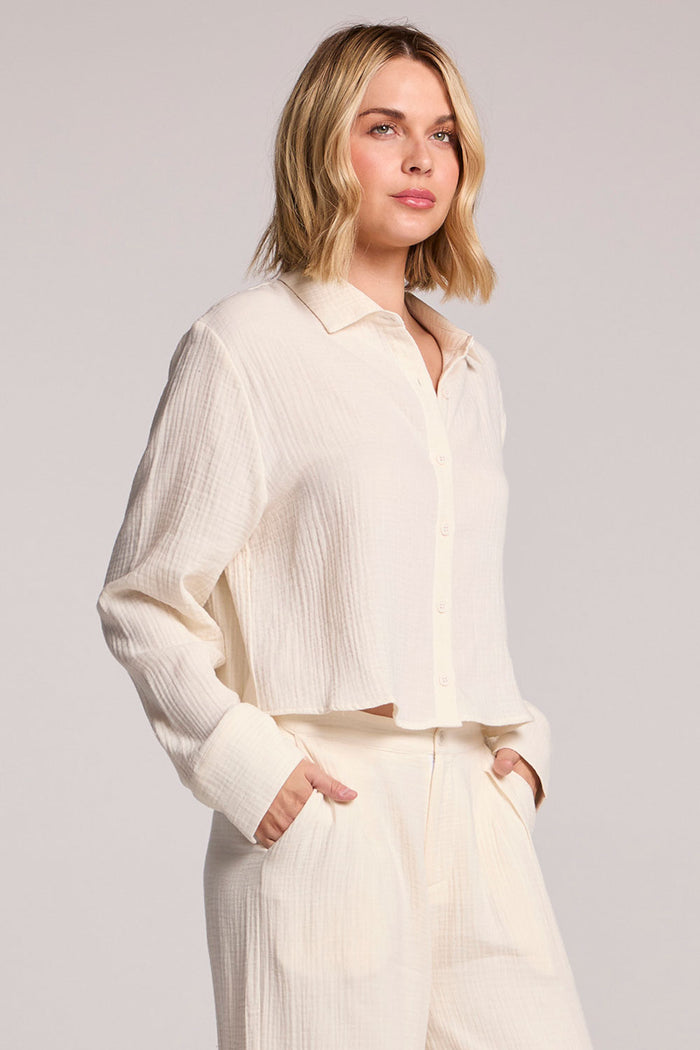 Side angle of a woman wearing the Chaser Paso Crop Button Up on a white background