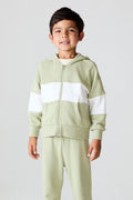 Front view of a boy wearing the Chaser Color Block Paxton Zip Up Hoodie and matching pants on a neutral background