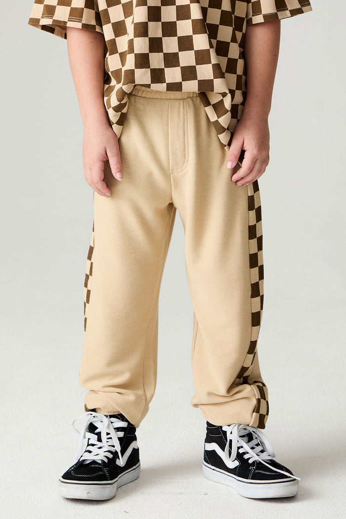 Front view of a boy wearing the Chaser Color Blocked Jogger on a neutral background with shirt and checkered pants