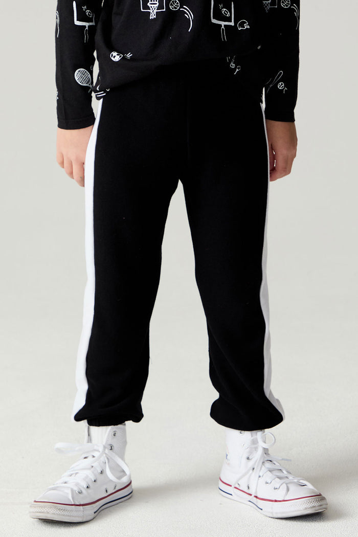 Side view of a boy wearing the Chaser Blocked Lounge Pants Boys Black Jogger on a neutral background with arms at sides and matching top