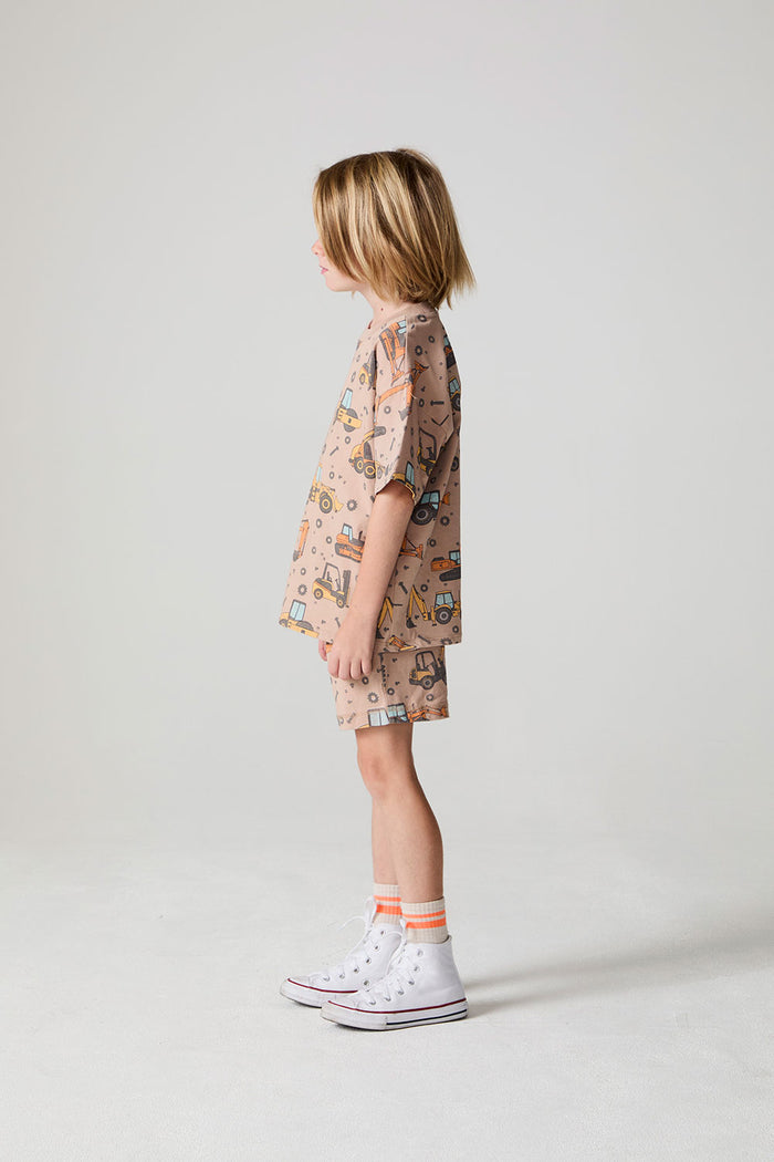 Full body side view of a boy wearing the Chaser Construction Days Tee on a neutral background