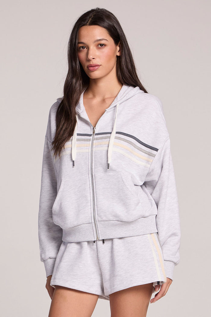 Front view of a woman wearing the Chaser Contrast Strappings Zip-Up and shorts on a neutral background