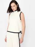 A woman wearing a cream high neck vest with short sleeves, a relaxed fit and a black contrast trim.