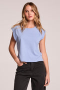 Front view of a woman wearing the Chaser Cropped Cap Sleeve Blue Hydrangea Crewneck Tee and jeans on a neutral background