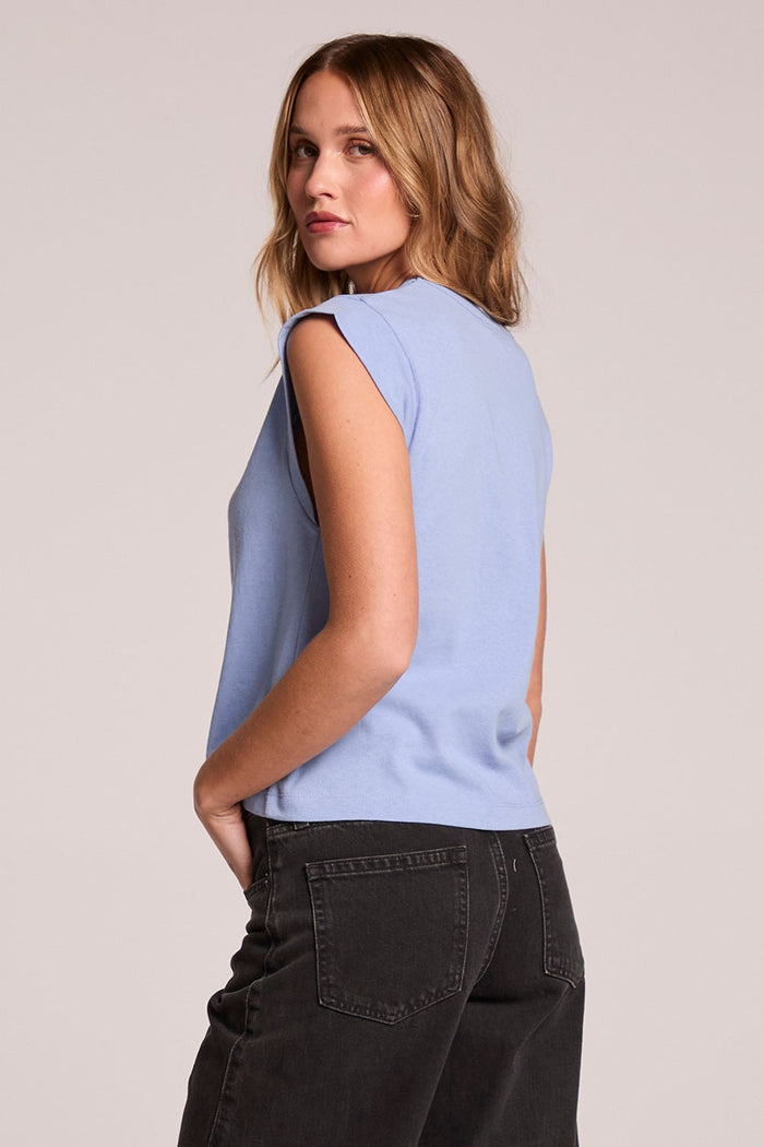 Back view of a woman wearing the Chaser Cropped Cap Sleeve Blue Hydrangea Crewneck Tee on a neutral background