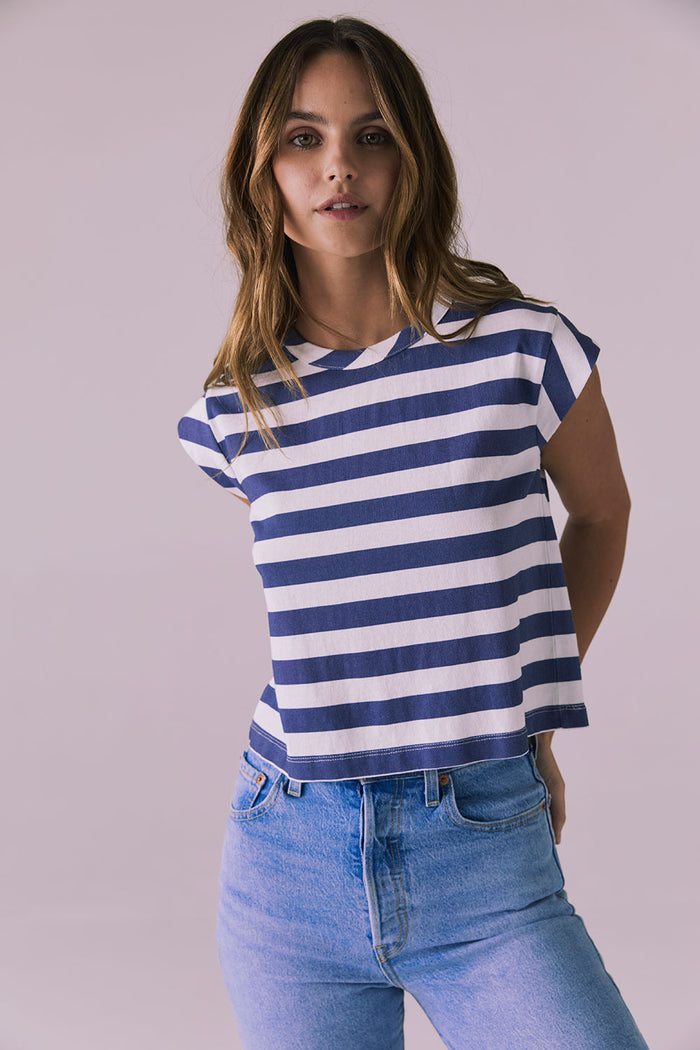 Model wearing the Chaser Cropped Castaway Stripe Cap Sleeve Crew Neck Tee featuring bold navy and white stripes and a relaxed cropped silhouette