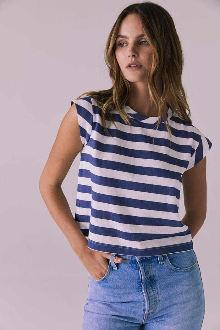 Model wearing the Chaser Cropped Castaway Stripe Cap Sleeve Crew Neck Tee featuring bold navy and white stripes and a relaxed cropped silhouette