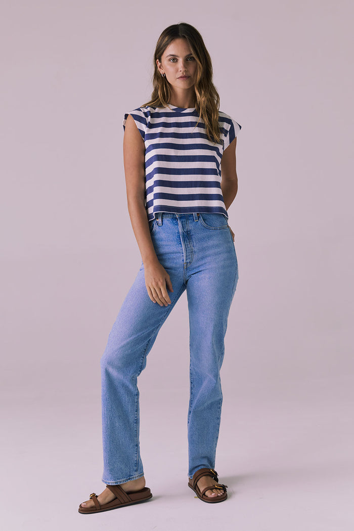 Model wearing the Chaser Cropped Castaway Stripe Cap Sleeve Crew Neck Tee with light wash jeans and sandals for an effortless coastal look