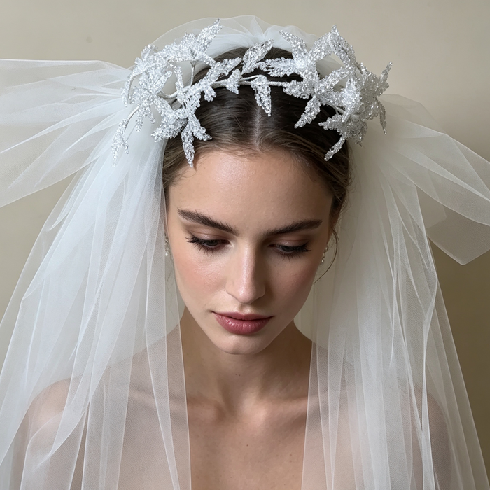 Bride wearing a sparkling flower crown veil headpiece with crystal details for a romantic wedding ceremony and bridal portrait.