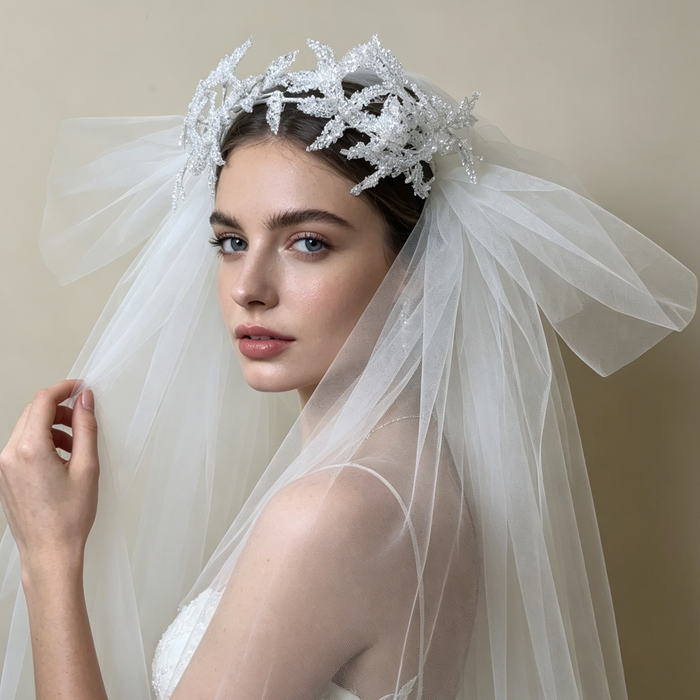 Bride wearing a sparkling flower crown veil headpiece with crystal details for a romantic wedding ceremony and bridal portrait.