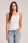 Front view of a woman wearing the Chaser    Daphne White Tank Top and jeans on a neutral background