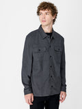 A man wearing a grey shirt with long sleeves, 2 front pockets, a pointed collar and button down fastening.