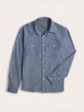 Dark wash blue chambray work shirt laid flat, showing two chest flap pockets.