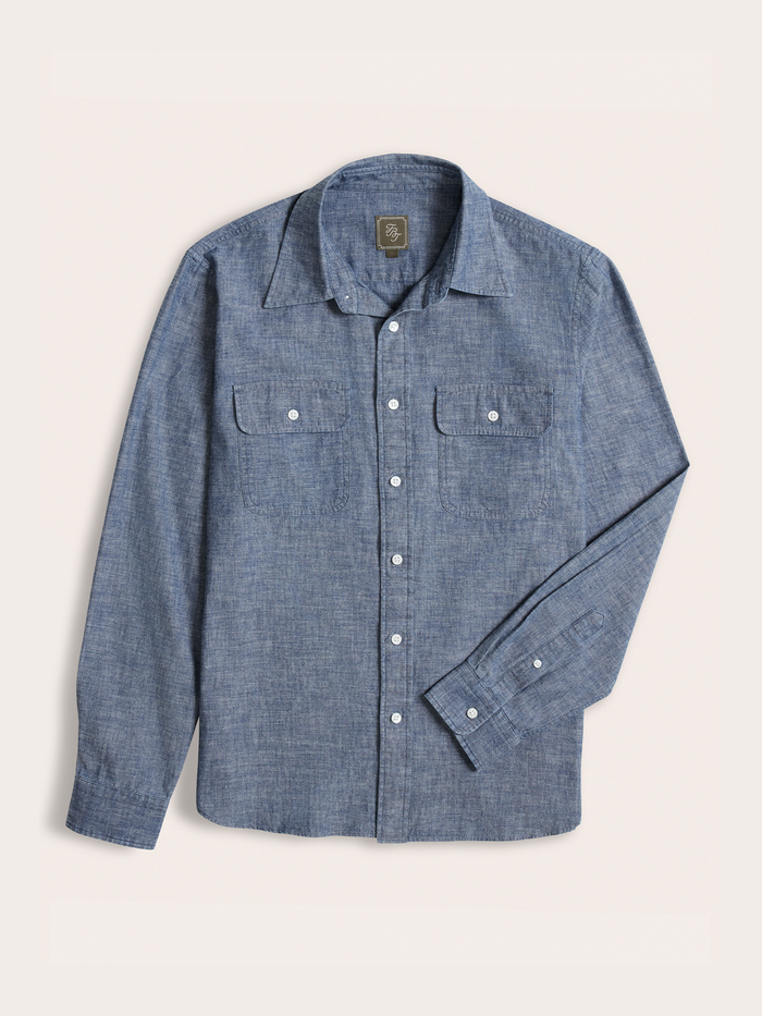 Dark wash blue chambray work shirt laid flat, showing two chest flap pockets.